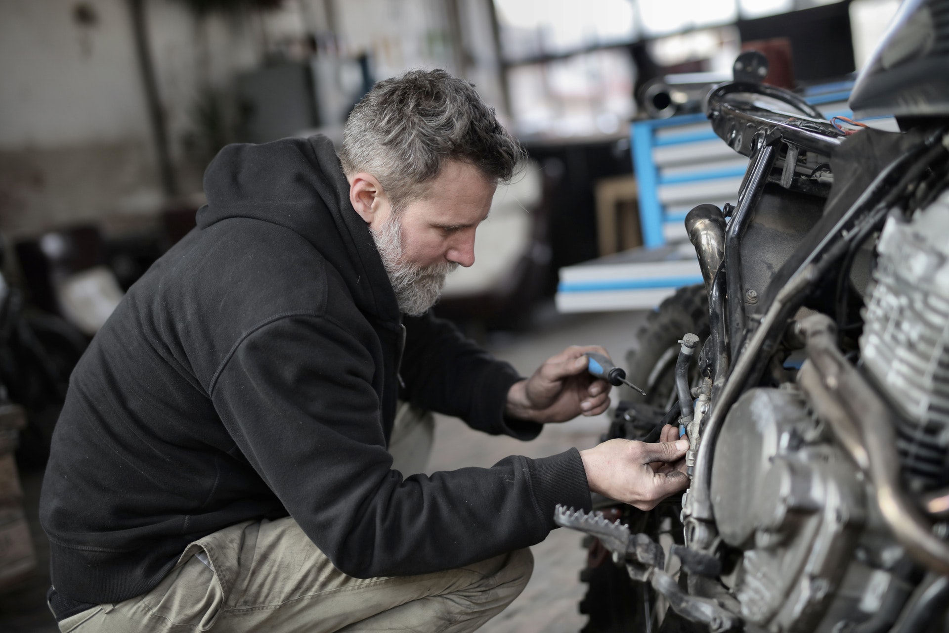Bearded man removing motorcycle tire
