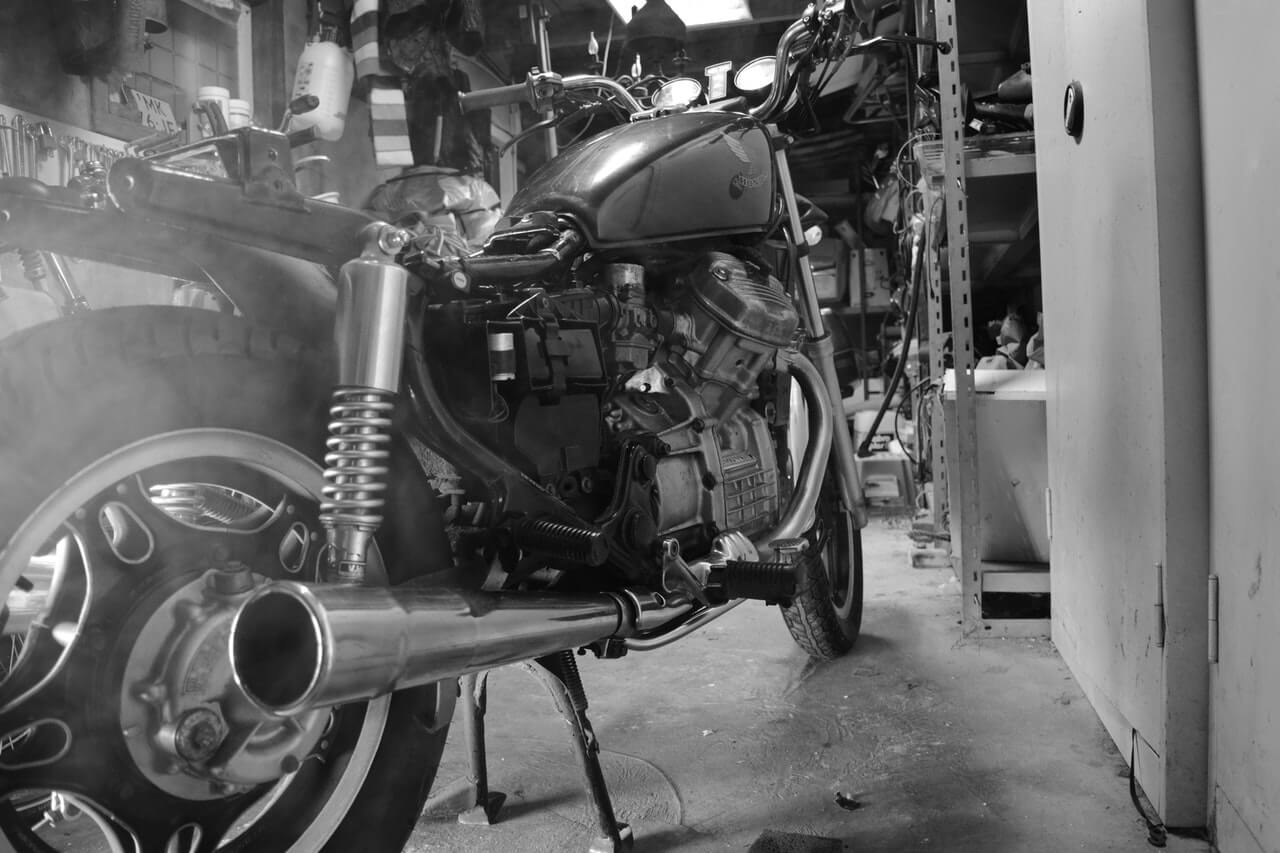black and white photo of the back of a motorcycle with an exhaust pipe