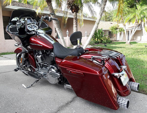 red and black motorcycle next to a palm tree