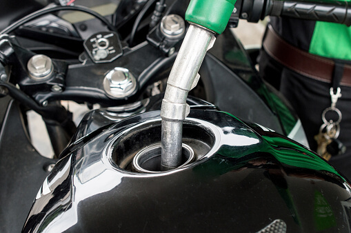 Close up of someone refilling fuel on their motorcycle