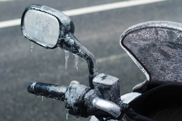 Motorcycle mirror covered in ice and icicles