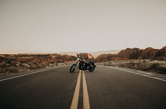 A large cruiser is parked on the yellow line of a lonely desert highway