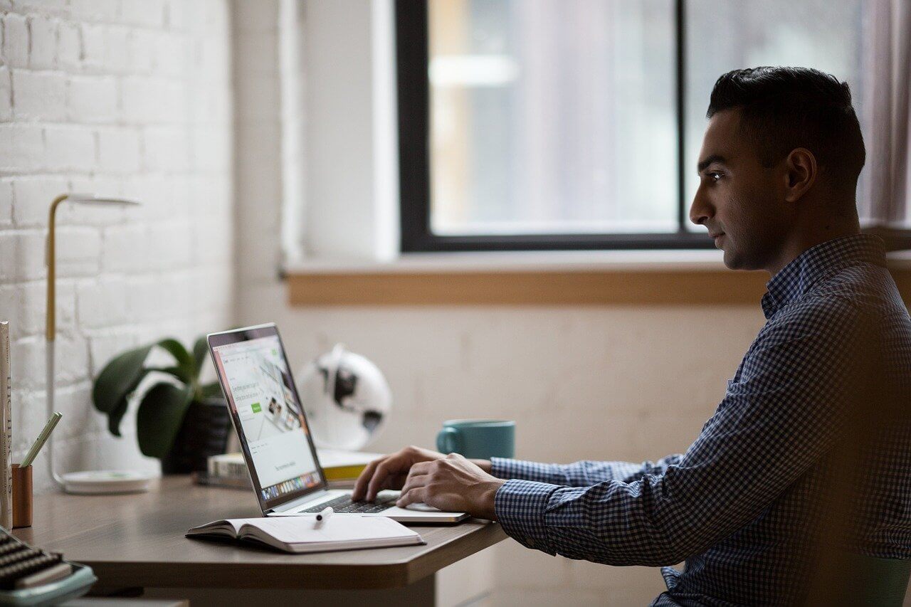 Man doing research on how to sell a motorcycle on his laptop