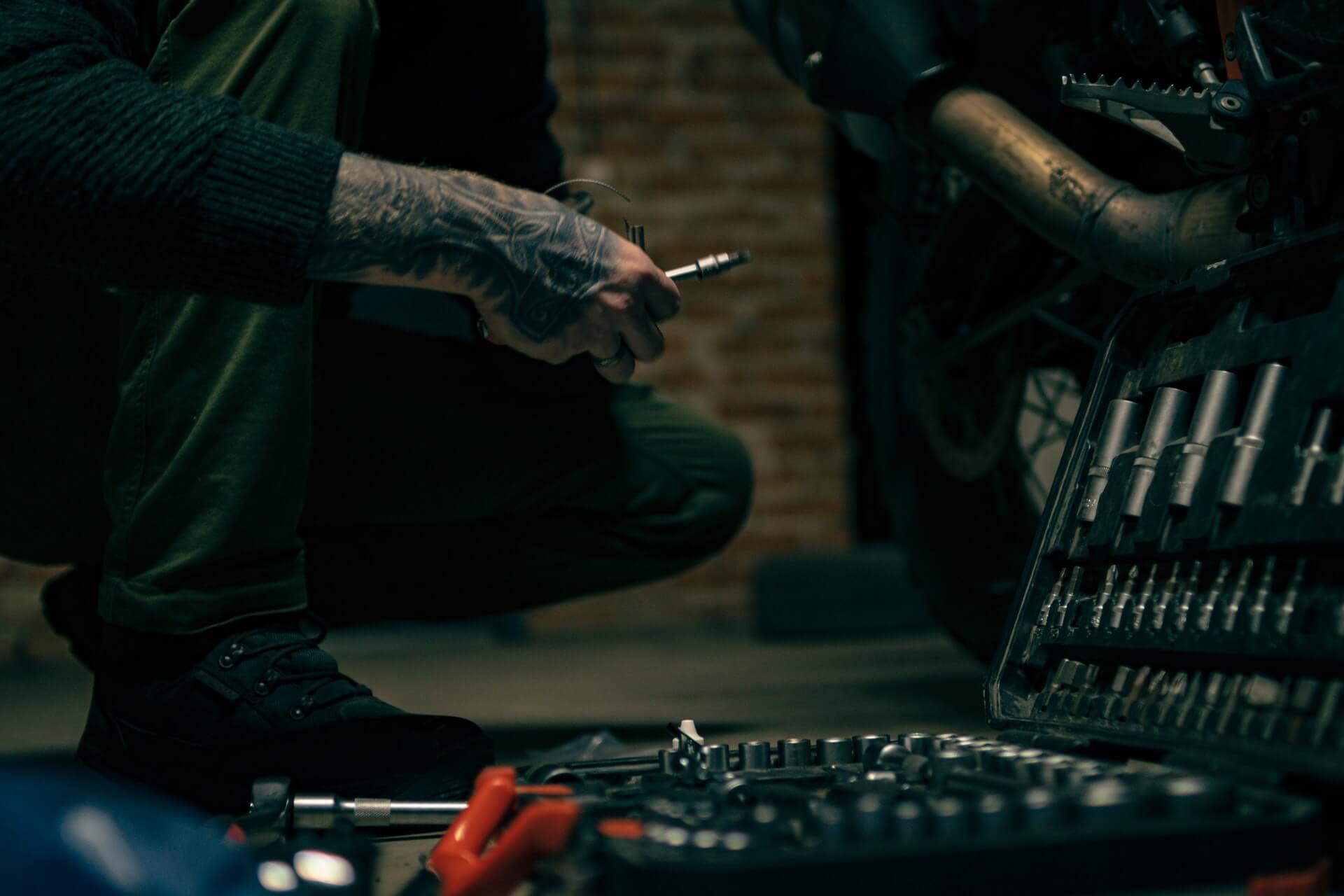 Man with tools removing spark plugs