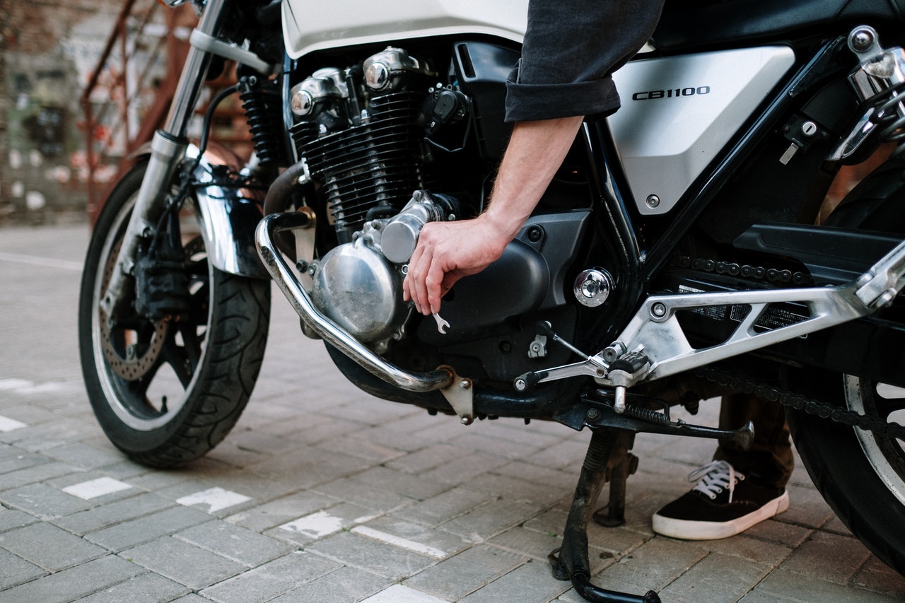 Man adjusting the body of his motorcycle