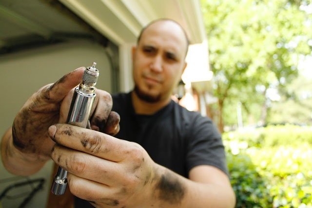 mechanic holding a spark plug