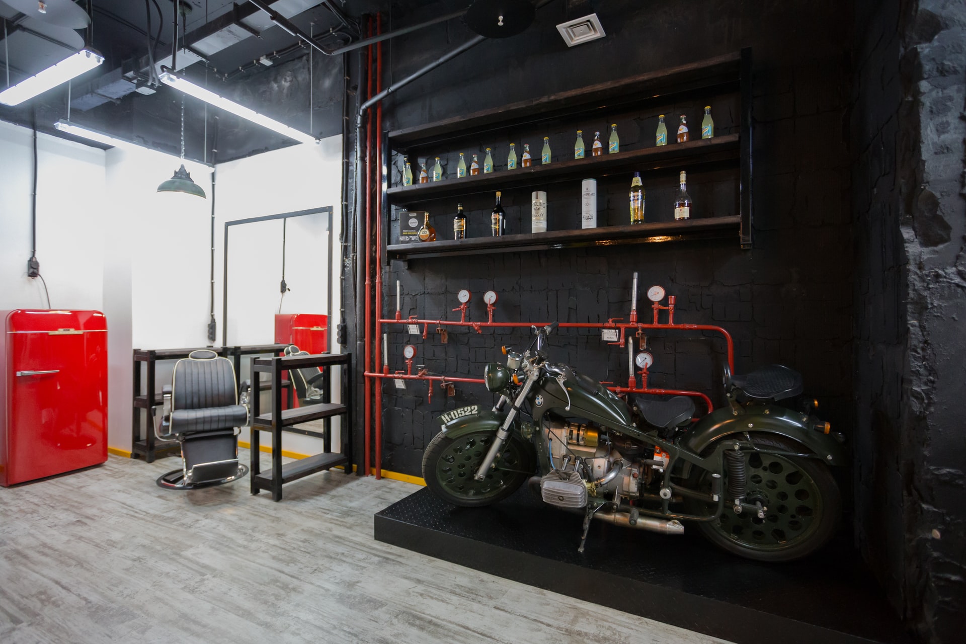 Motorcycle being held in a sterile room with a black wall and red room accents