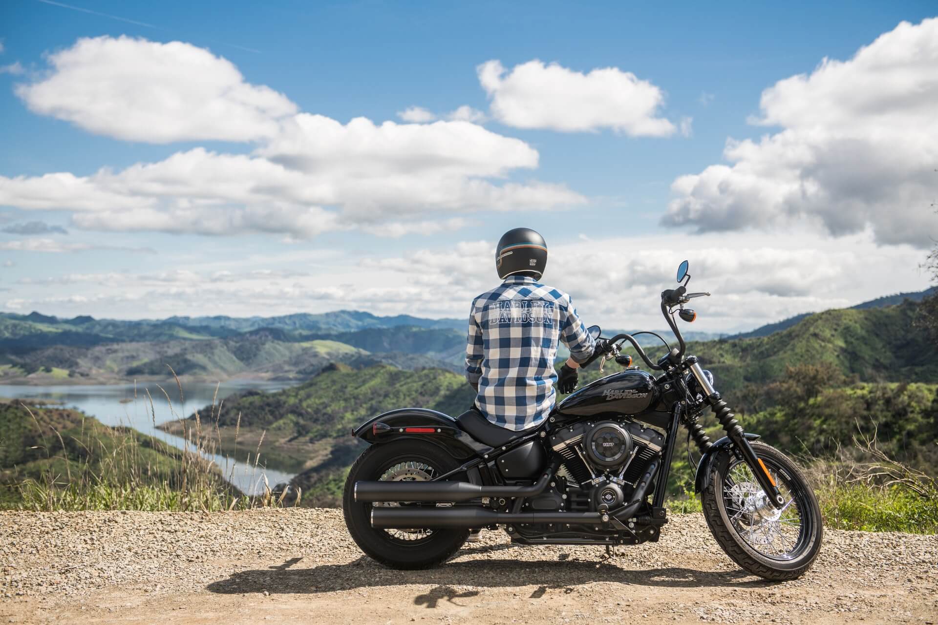 Man sitting on motorcycle looking at mountains