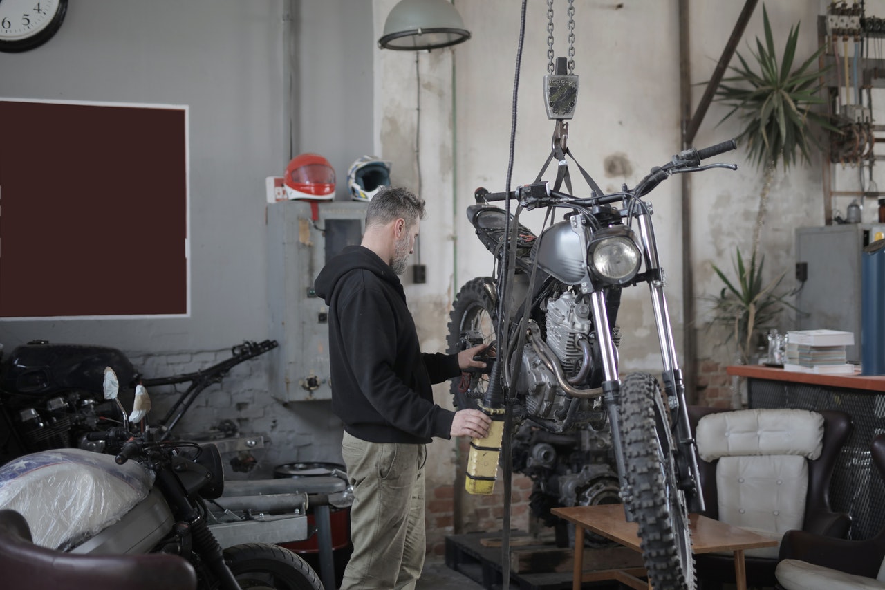Man with a motorcycle up on a work table