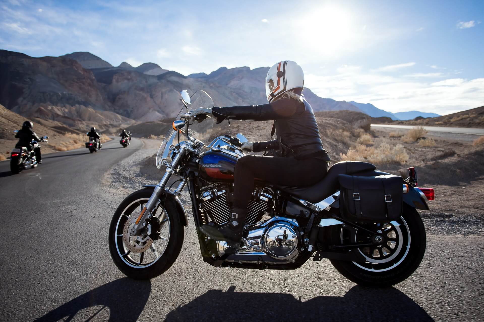 Person riding their motorcycle around a mountain with a well-fitted windshield