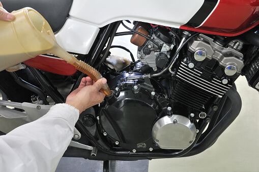 Closeup of someone changing the oil of their motorcycle