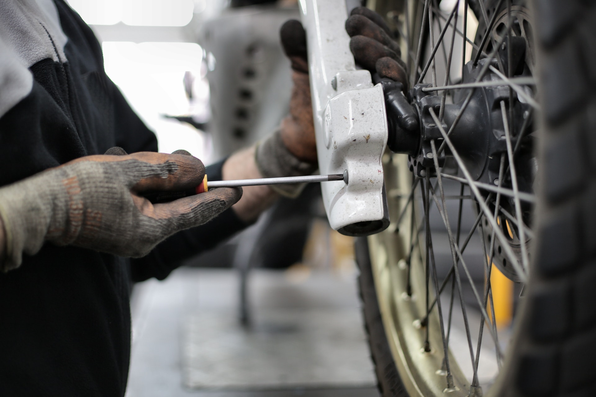 person putting motorcycle tire back on