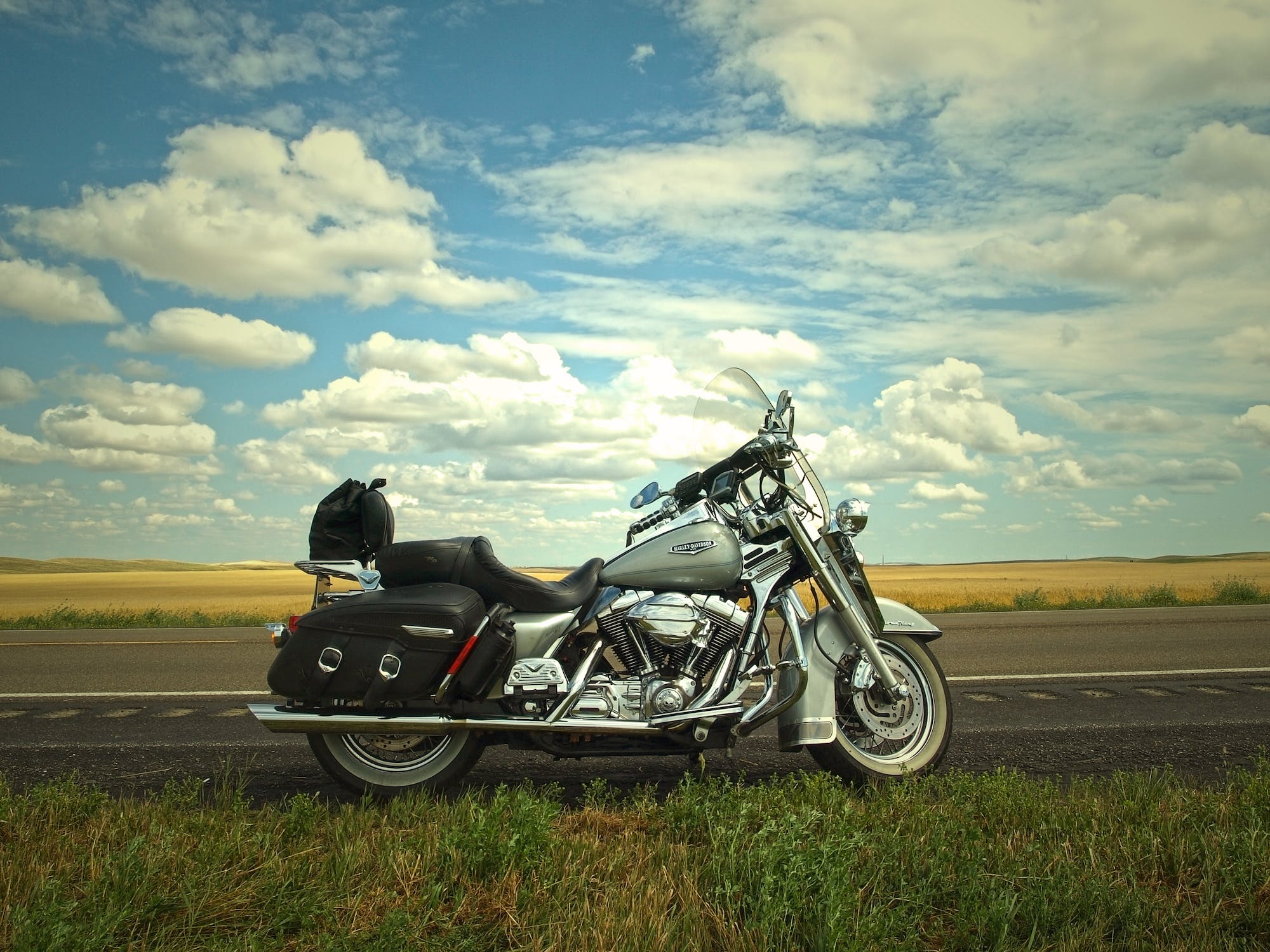 silver and black cruiser motorcycle parked on the edge of the road