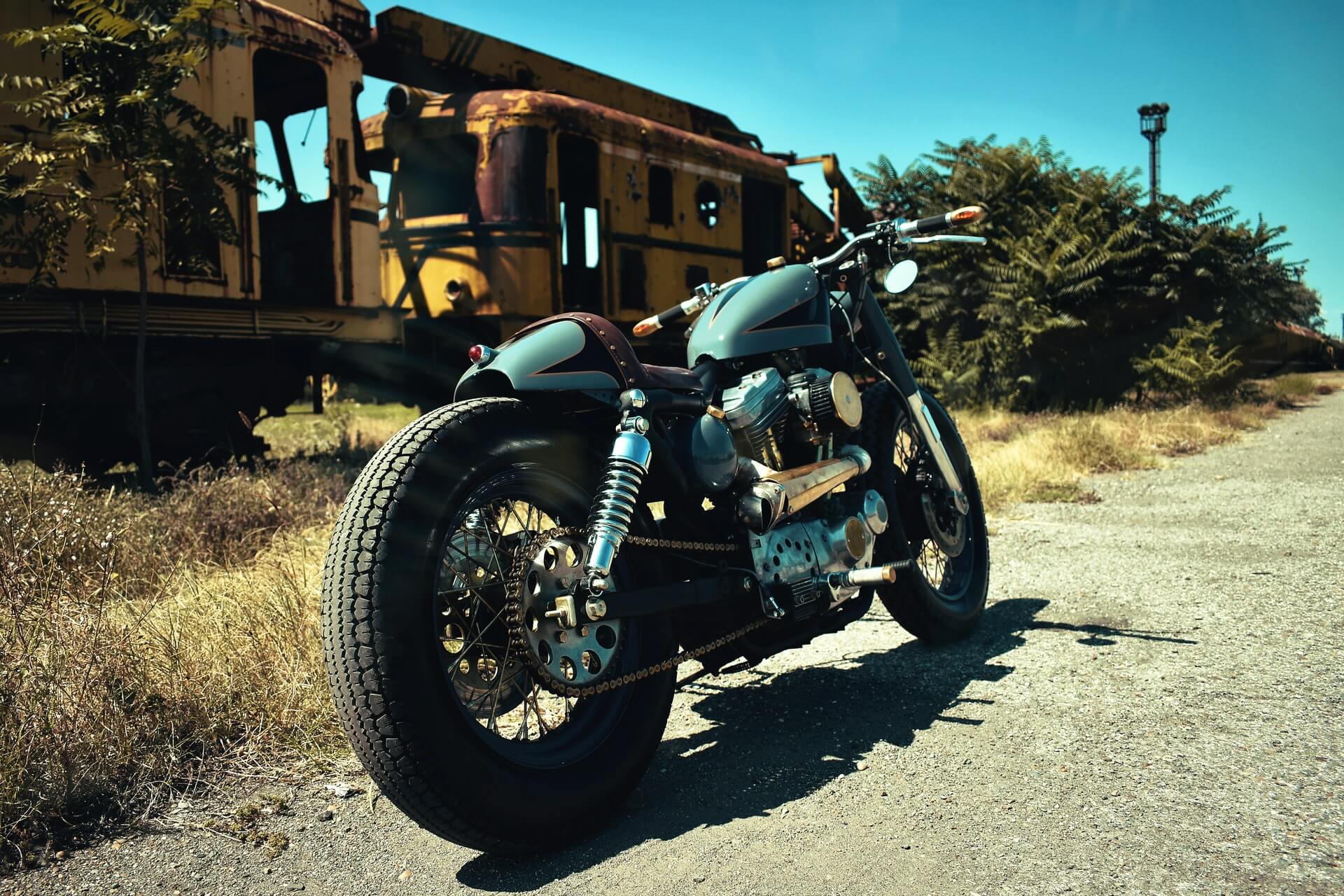 Retro motorcycle near a rusted train